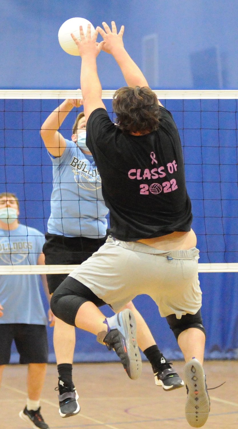 Air time. Sullivan West senior Chris Campanelli takes time off from the gridiron to send one over the net against juniors Max Ebert and Dillan Hanslmaier (in the background).